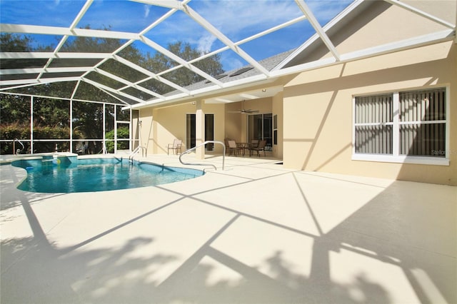 pool featuring a patio, a ceiling fan, and glass enclosure