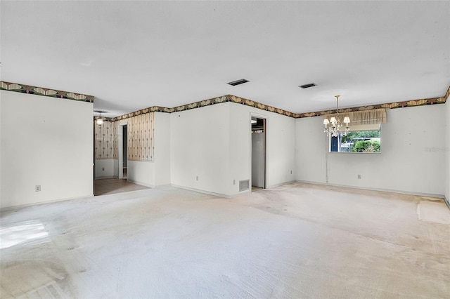 empty room with an inviting chandelier, baseboards, visible vents, and light colored carpet