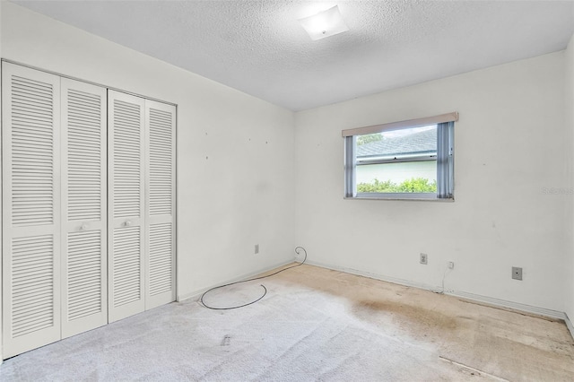unfurnished bedroom with a closet, baseboards, carpet flooring, and a textured ceiling