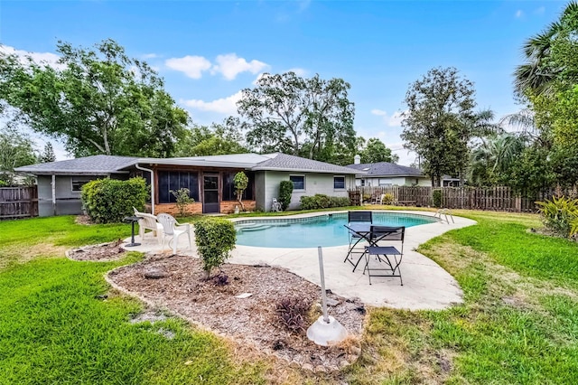view of pool featuring a fenced backyard, a sunroom, a fenced in pool, a patio area, and a lawn