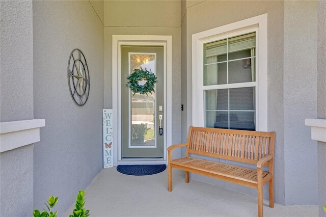 property entrance featuring stucco siding and a porch