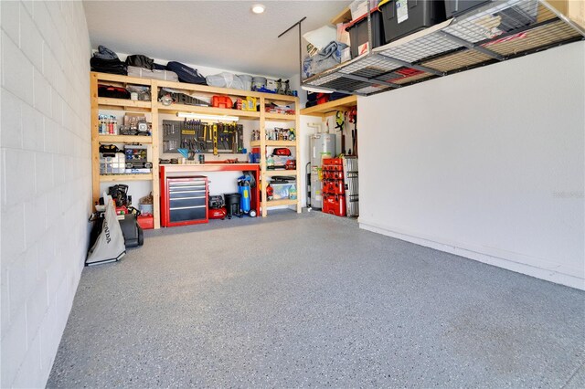 garage with water heater and a workshop area