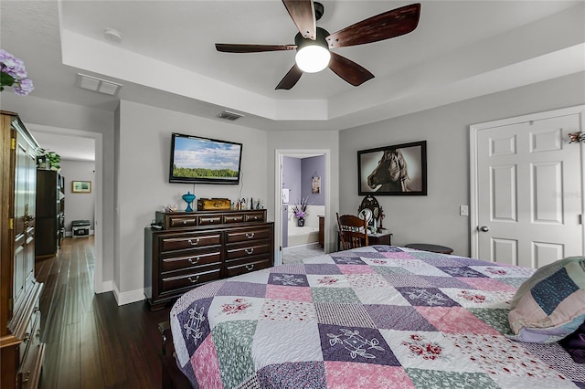 913 Bending Oak Trl, Winter Garden, FL 34787 - bedroom with a tray ceiling, dark wood-type flooring, baseboards, a ceiling fan, and connected bathroom