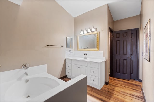 114 Shaddock Dr, Auburndale, FL 33823 - bathroom with vanity, a bath, and wood finished floors