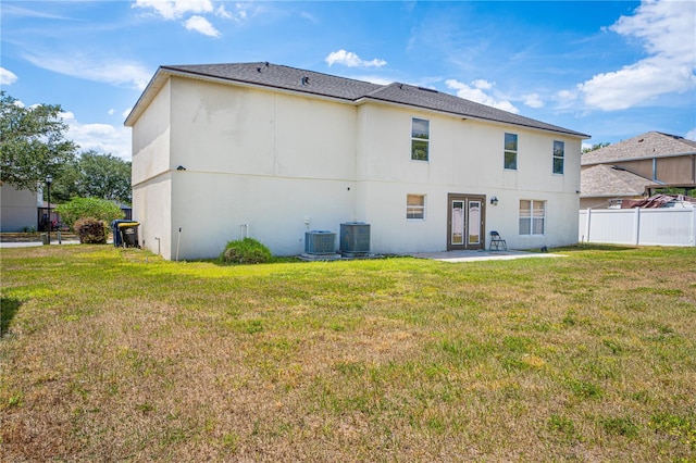 114 Shaddock Dr, Auburndale, FL 33823 - back of property with fence, french doors, central AC unit, and a patio area