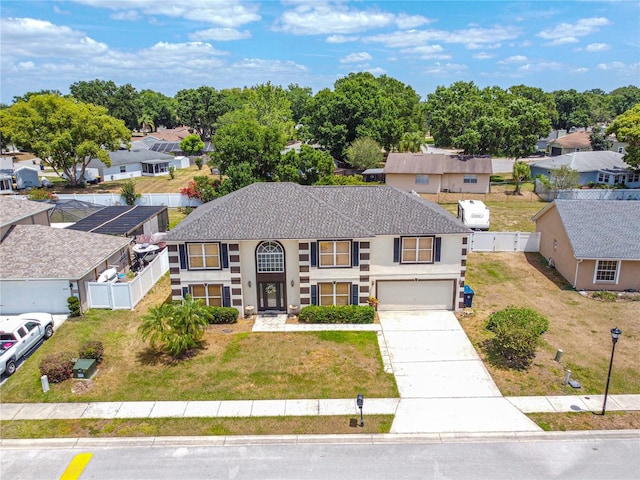 114 Shaddock Dr, Auburndale, FL 33823 - view of front facade with a residential view, fence, an attached garage, stucco siding, and driveway