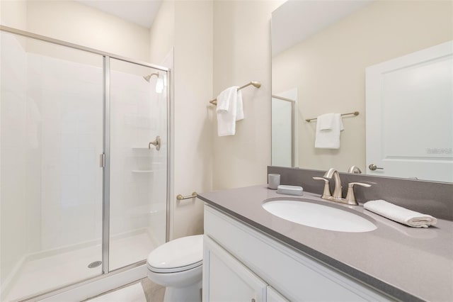 full bathroom featuring vanity, a shower stall, and toilet
