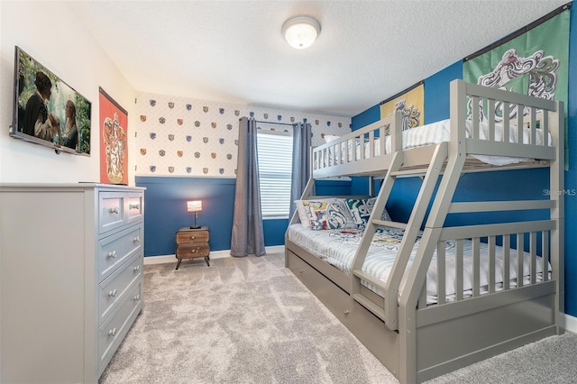 carpeted bedroom with baseboards, a textured ceiling, and wallpapered walls