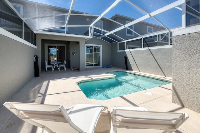 outdoor pool with a patio and glass enclosure