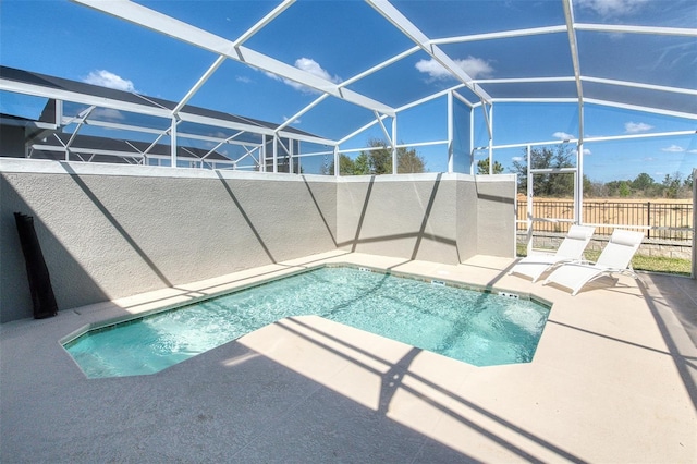 view of swimming pool with glass enclosure, a patio, a fenced in pool, and fence