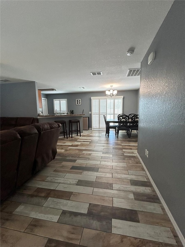 interior space featuring visible vents, baseboards, and a notable chandelier