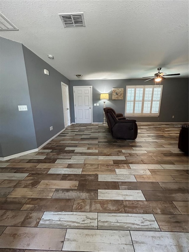 sitting room with visible vents, a ceiling fan, a textured ceiling, and wood finished floors