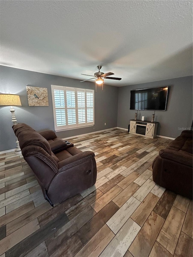 living room with wood-type flooring, a textured ceiling, and ceiling fan