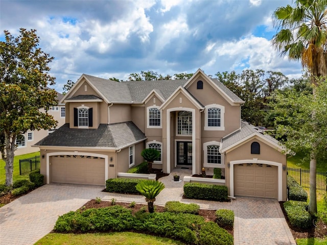 14003 Hampshire Bay Cir, Winter Garden, FL 34787 - traditional-style house with fence, decorative driveway, stucco siding, french doors, and an attached garage