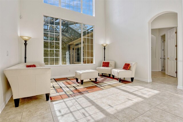 14003 Hampshire Bay Cir, Winter Garden, FL 34787 - sitting room featuring baseboards, arched walkways, a high ceiling, and light tile patterned floors