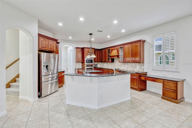 14003 Hampshire Bay Cir, Winter Garden, FL 34787 - kitchen with decorative backsplash, arched walkways, a center island, custom range hood, and stainless steel appliances