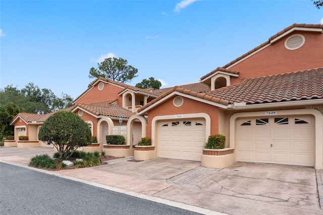 7449 Sugar Bend Dr Unit 7449, Orlando, FL 32819 - mediterranean / spanish house with driveway, a garage, stucco siding, and a tile roof
