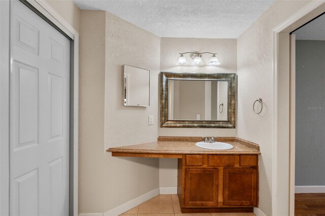 7449 Sugar Bend Dr Unit 7449, Orlando, FL 32819 - bathroom with a textured ceiling, baseboards, vanity, tile patterned flooring, and a textured wall