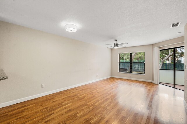 7449 Sugar Bend Dr Unit 7449, Orlando, FL 32819 - unfurnished room with ceiling fan, light wood-style floors, baseboards, and a textured ceiling