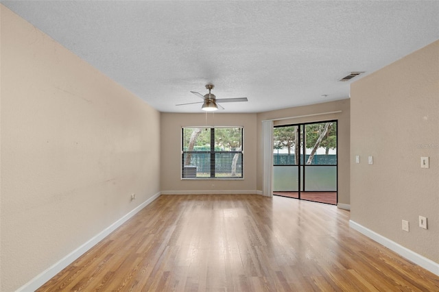 7449 Sugar Bend Dr Unit 7449, Orlando, FL 32819 - spare room featuring light wood-style flooring, a ceiling fan, a textured ceiling, and baseboards