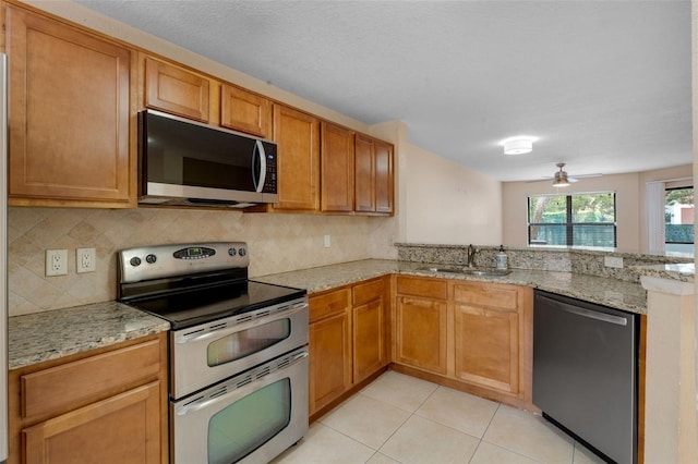 7449 Sugar Bend Dr Unit 7449, Orlando, FL 32819 - kitchen with appliances with stainless steel finishes, a sink, backsplash, and light stone counters