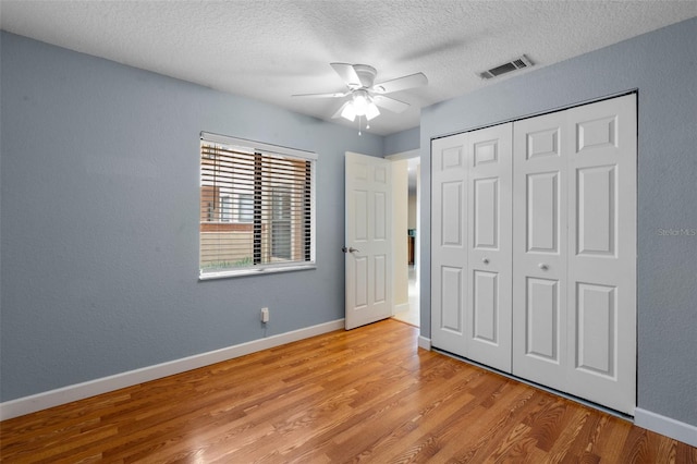 7449 Sugar Bend Dr Unit 7449, Orlando, FL 32819 - unfurnished bedroom with light wood finished floors, a textured ceiling, a closet, baseboards, and ceiling fan