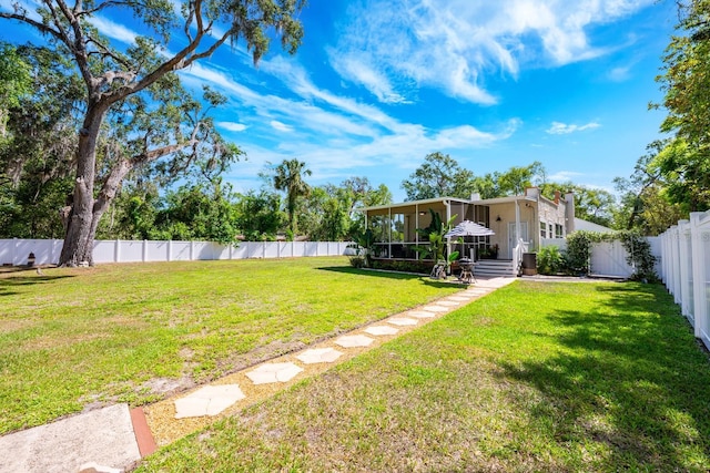 view of yard with a sunroom and a fenced backyard