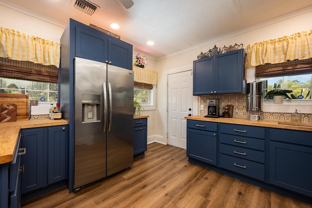 kitchen with wooden counters, stainless steel fridge, and blue cabinetry