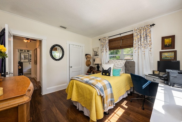 bedroom with baseboards, ornamental molding, visible vents, and wood finished floors