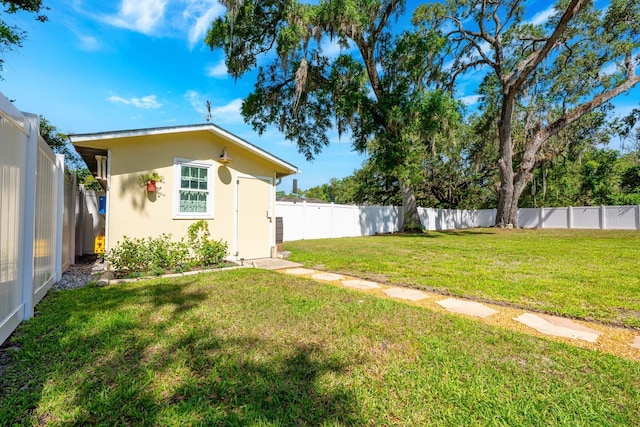 view of yard with a fenced backyard and an outbuilding