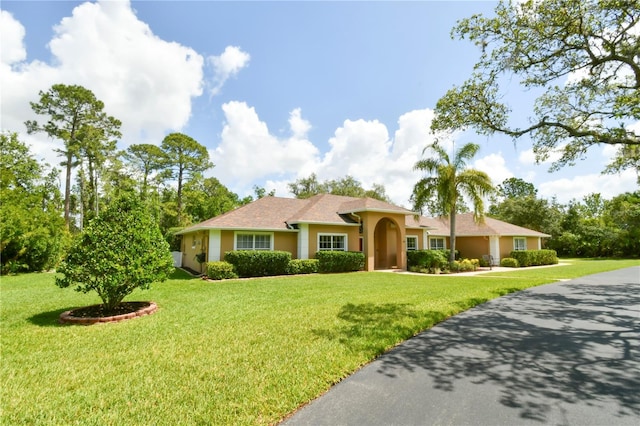 view of front of house featuring stucco siding and a front yard