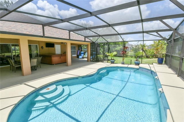 outdoor pool featuring a hot tub, a patio area, and a lanai