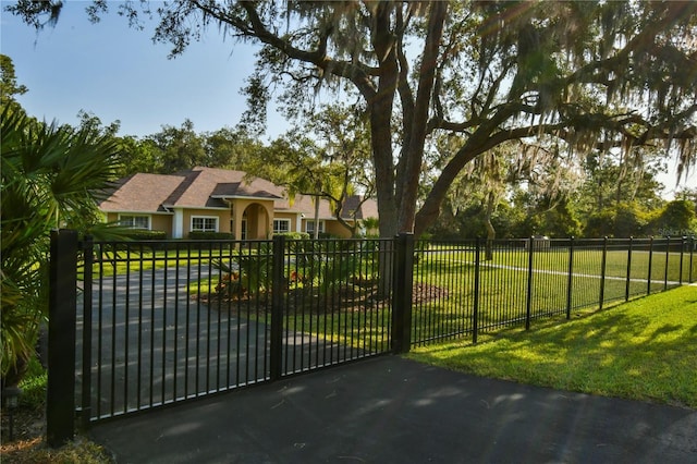 view of gate featuring a lawn and fence