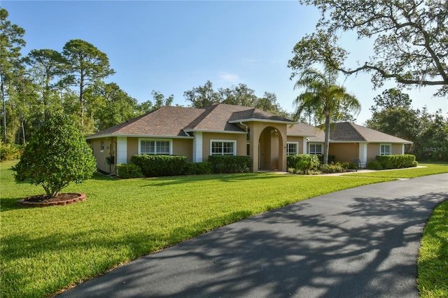 single story home with stucco siding and a front yard