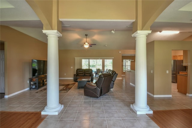 living area featuring light tile patterned floors, a ceiling fan, ornate columns, and lofted ceiling