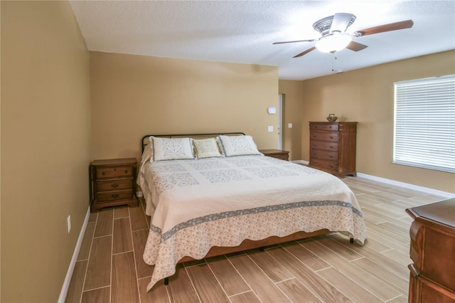 bedroom featuring wood tiled floor, baseboards, and ceiling fan