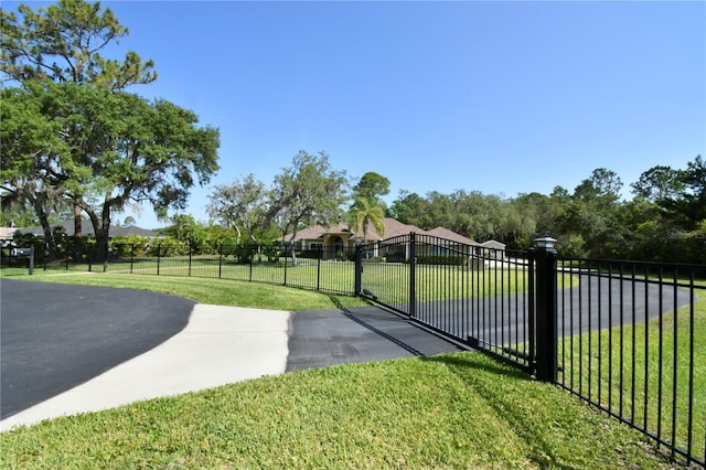 view of gate featuring fence and a yard