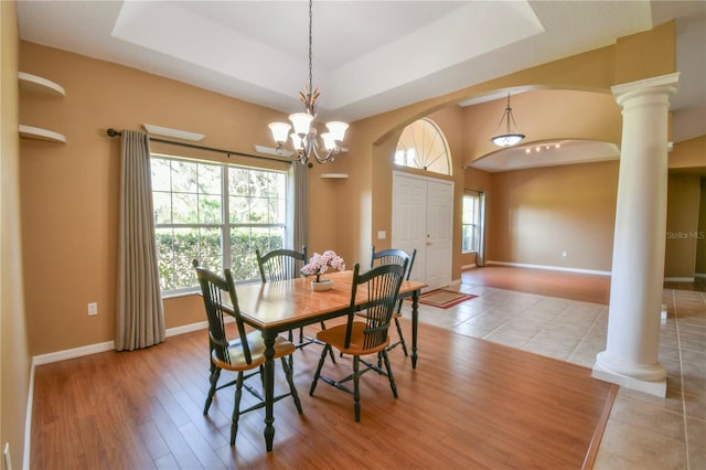 dining space with baseboards, ornate columns, arched walkways, and a wealth of natural light