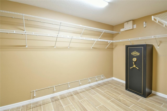 walk in closet with wood finish floors