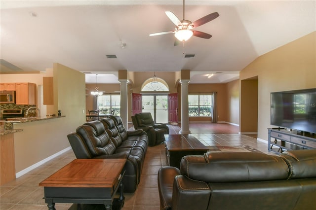 living room with visible vents, a ceiling fan, decorative columns, light tile patterned floors, and vaulted ceiling