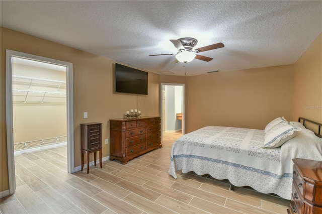 bedroom with a textured ceiling, baseboards, and wood tiled floor