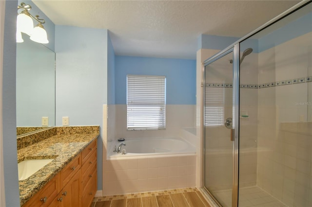full bath with vanity, a shower stall, a garden tub, and wood finished floors