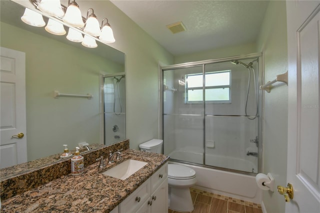 full bathroom with shower / bath combination with glass door, an inviting chandelier, vanity, toilet, and visible vents