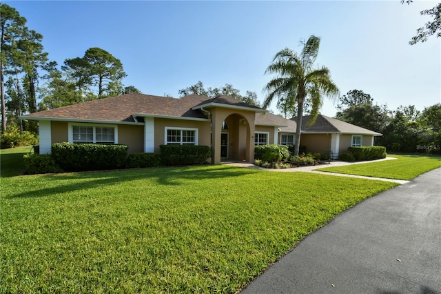 ranch-style home with a front yard and stucco siding