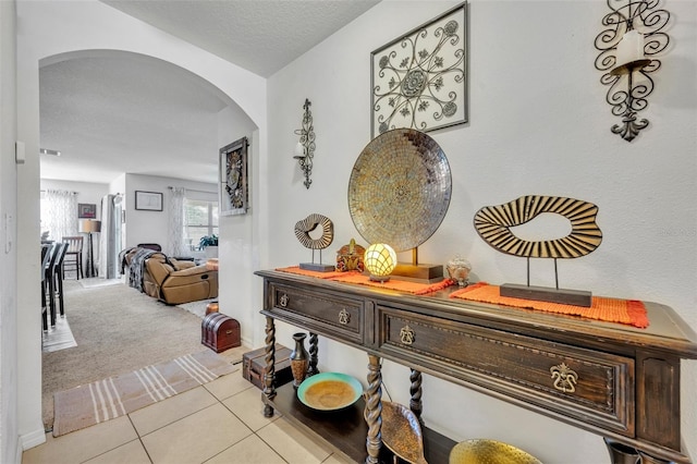822 Sheen Cir, Haines City, FL 33844 - hallway with carpet floors, arched walkways, and tile patterned floors