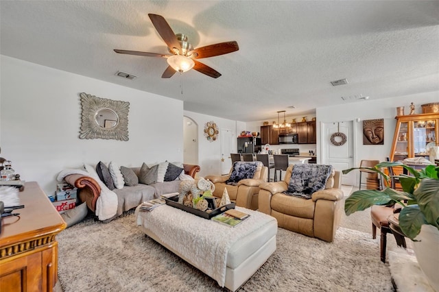 822 Sheen Cir, Haines City, FL 33844 - living room featuring visible vents, a ceiling fan, a textured ceiling, and arched walkways