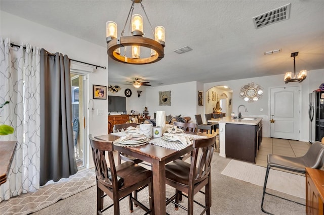 822 Sheen Cir, Haines City, FL 33844 - dining area featuring visible vents, arched walkways, ceiling fan with notable chandelier, and light carpet