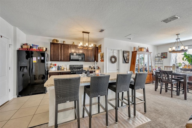 822 Sheen Cir, Haines City, FL 33844 - kitchen featuring an inviting chandelier, dark brown cabinetry, black appliances, and visible vents