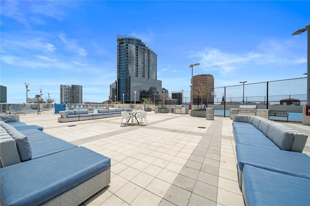 view of patio / terrace with fence, a city view, and an outdoor hangout area