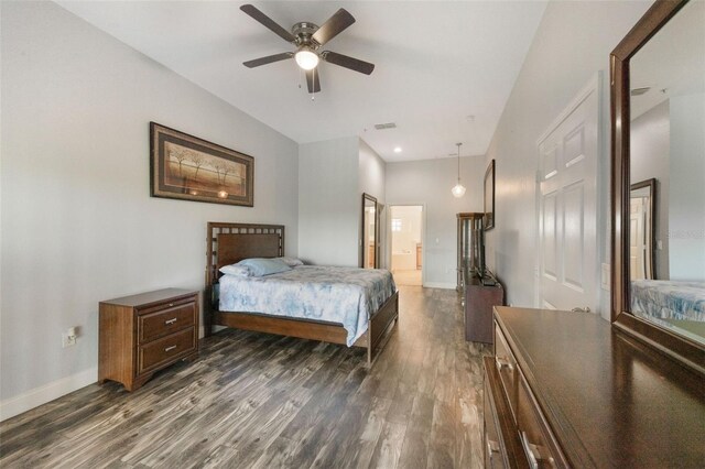 bedroom featuring dark wood-type flooring, baseboards, and ensuite bathroom